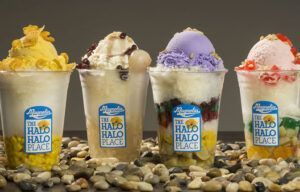 Four cups of ice cream are sitting on top of a pile of rocks.