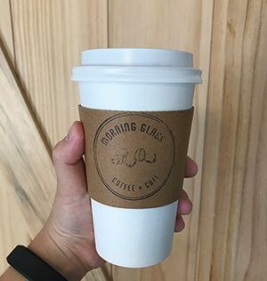A person is holding a cup of coffee in their hand.
