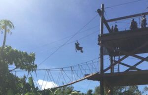 A person is flying through the air on a zip line.