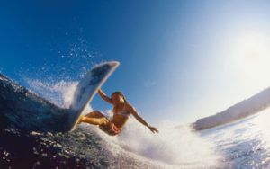 A woman is riding a wave on a surfboard in the ocean.