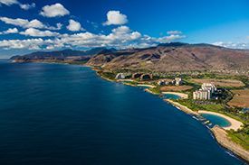An aerial view of a large body of water with mountains in the background.