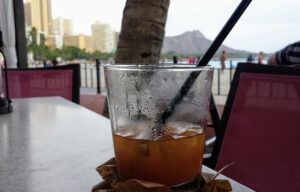 A glass of iced tea with a straw on a table.