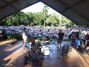 A group of people are playing instruments on a stage in front of a crowd.