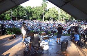 A band is playing in front of a large crowd