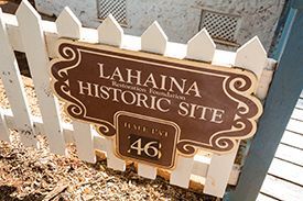 A sign on a white picket fence says la haina historic site .46.