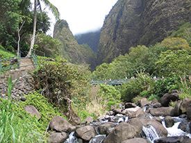 A river flowing through a valley surrounded by trees and rocks.