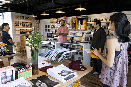 A group of people are standing around a table in a store.