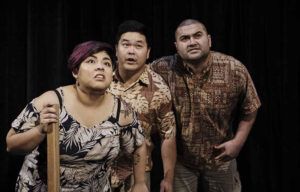 A group of three people are standing next to each other on a stage.