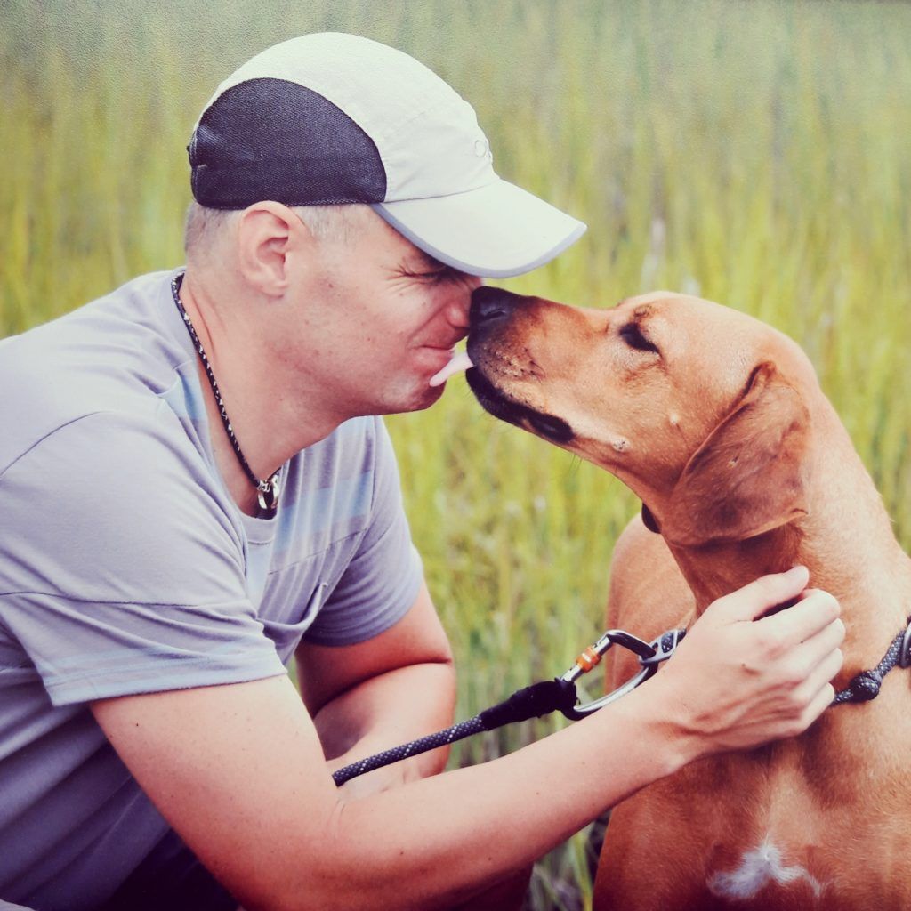 Man getting kissed by therapy pet
