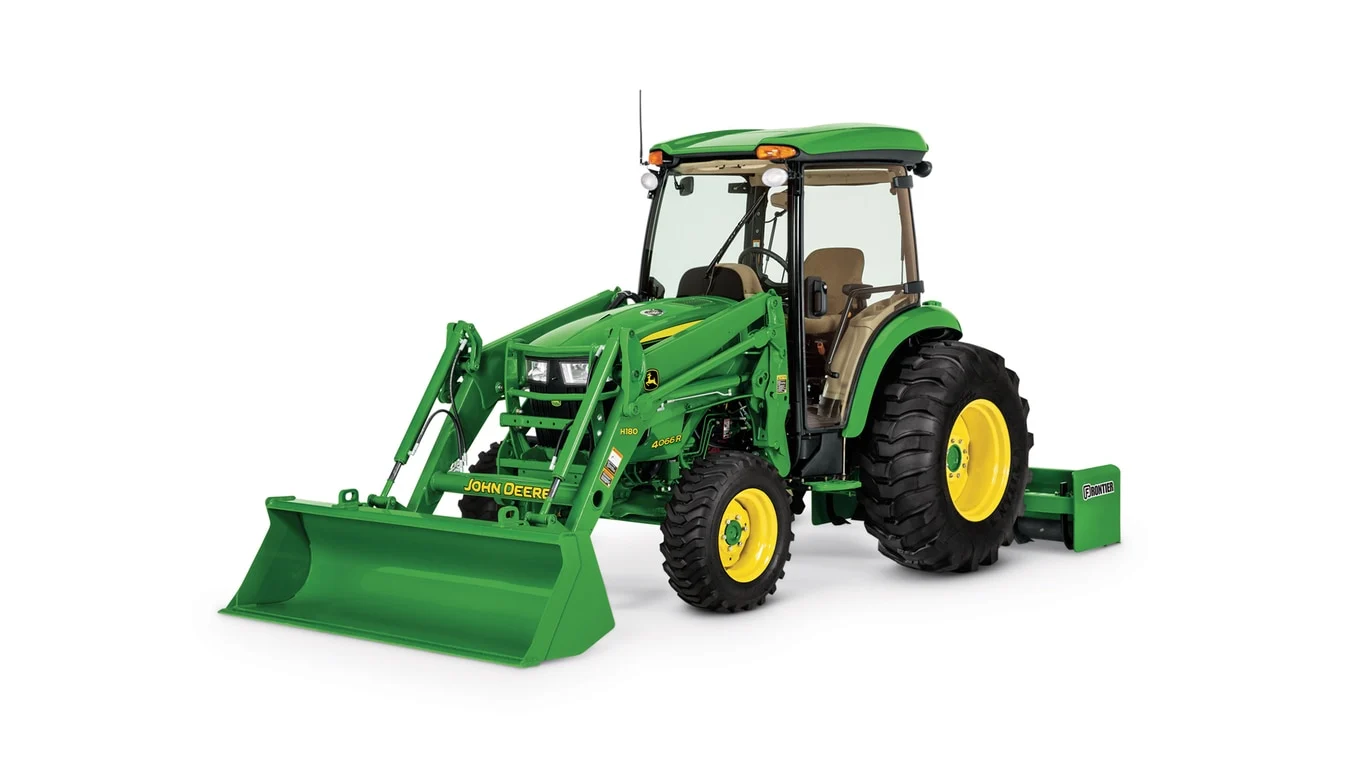 Green 4066R tractor with yellow wheels working in a field under a clear sky