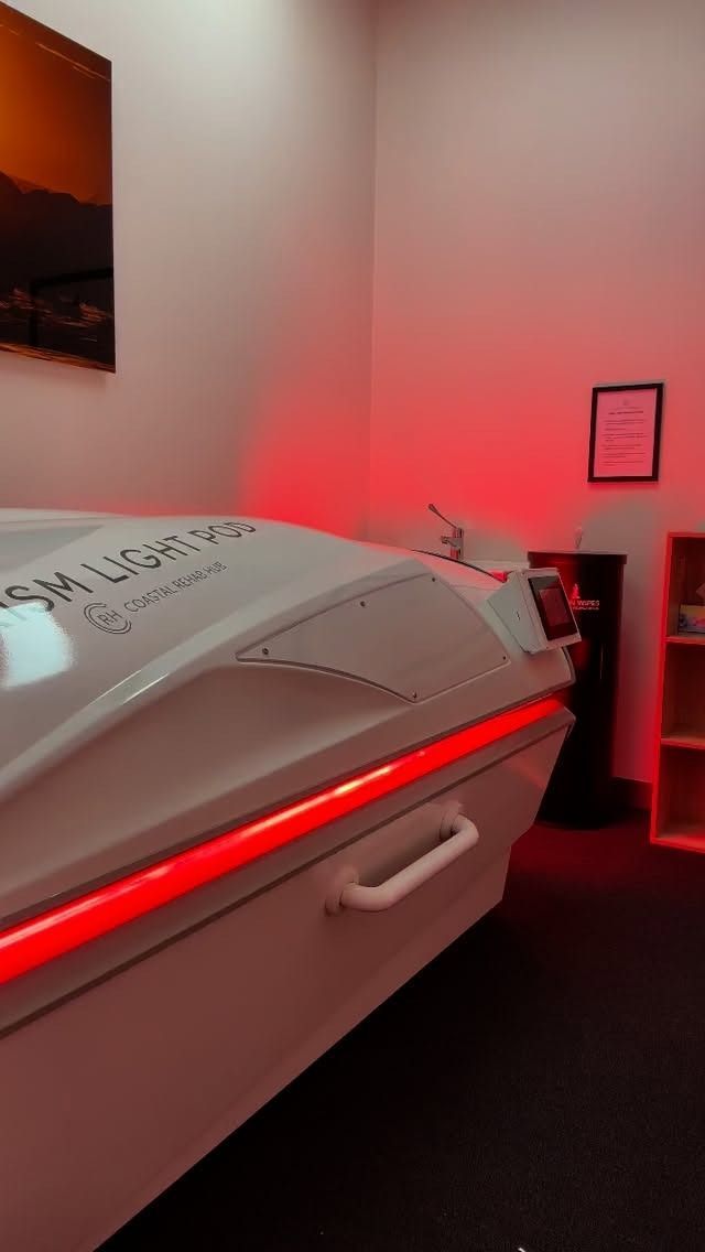 Woman receiving laser treatment on arm from a smiling healthcare professional; both wear protective eyewear.