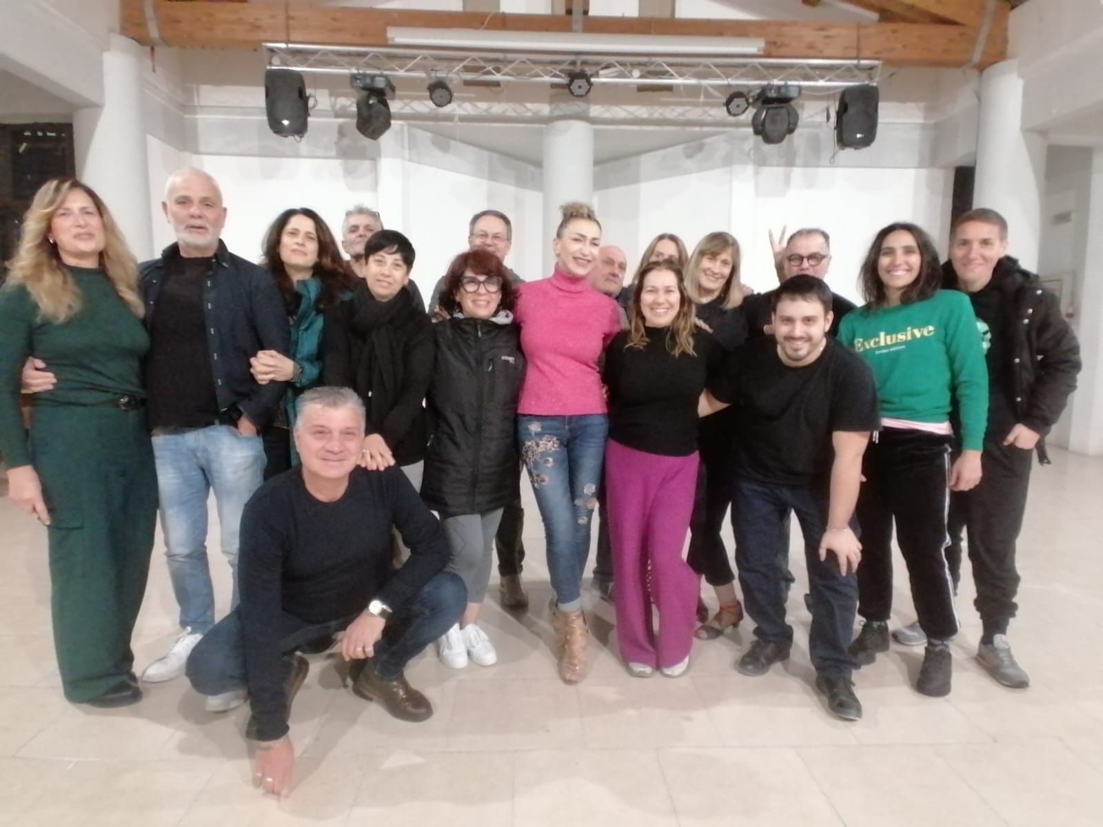 Lo chef in camice bianco e grembiule a righe sorride, seduto fuori.