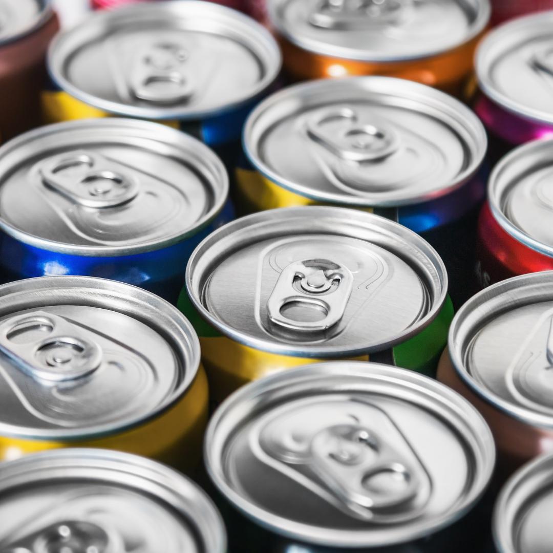 Close-up of assorted colorful aluminum soda cans with silver tops arranged in a cluster