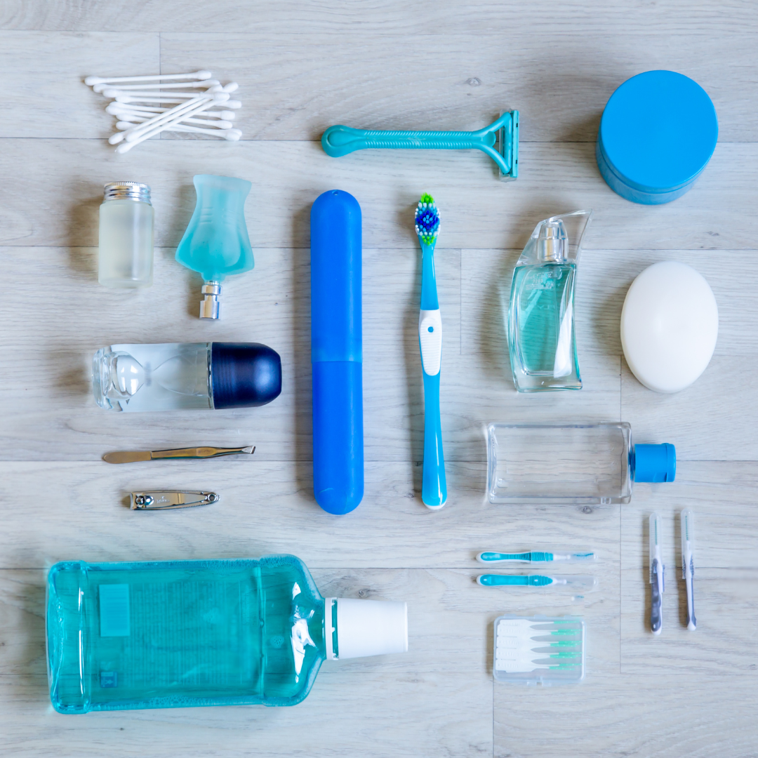 Assorted blue-and-white personal care items, including toothpaste, razor, toothbrush, and bottles, arranged on a light surface