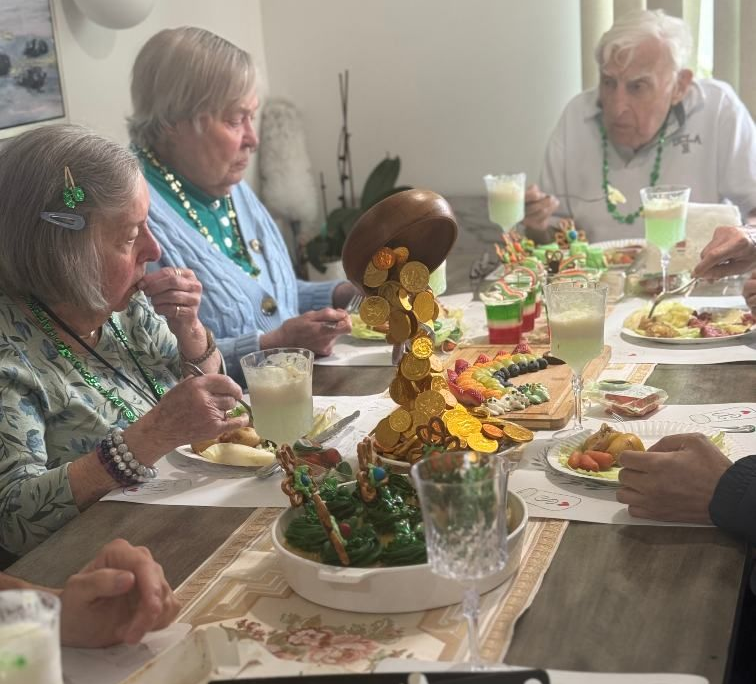 Elderly people at a table, enjoying tea and desserts. Interior shot, bright. Coral Tree Care Home in Lomita, CA.