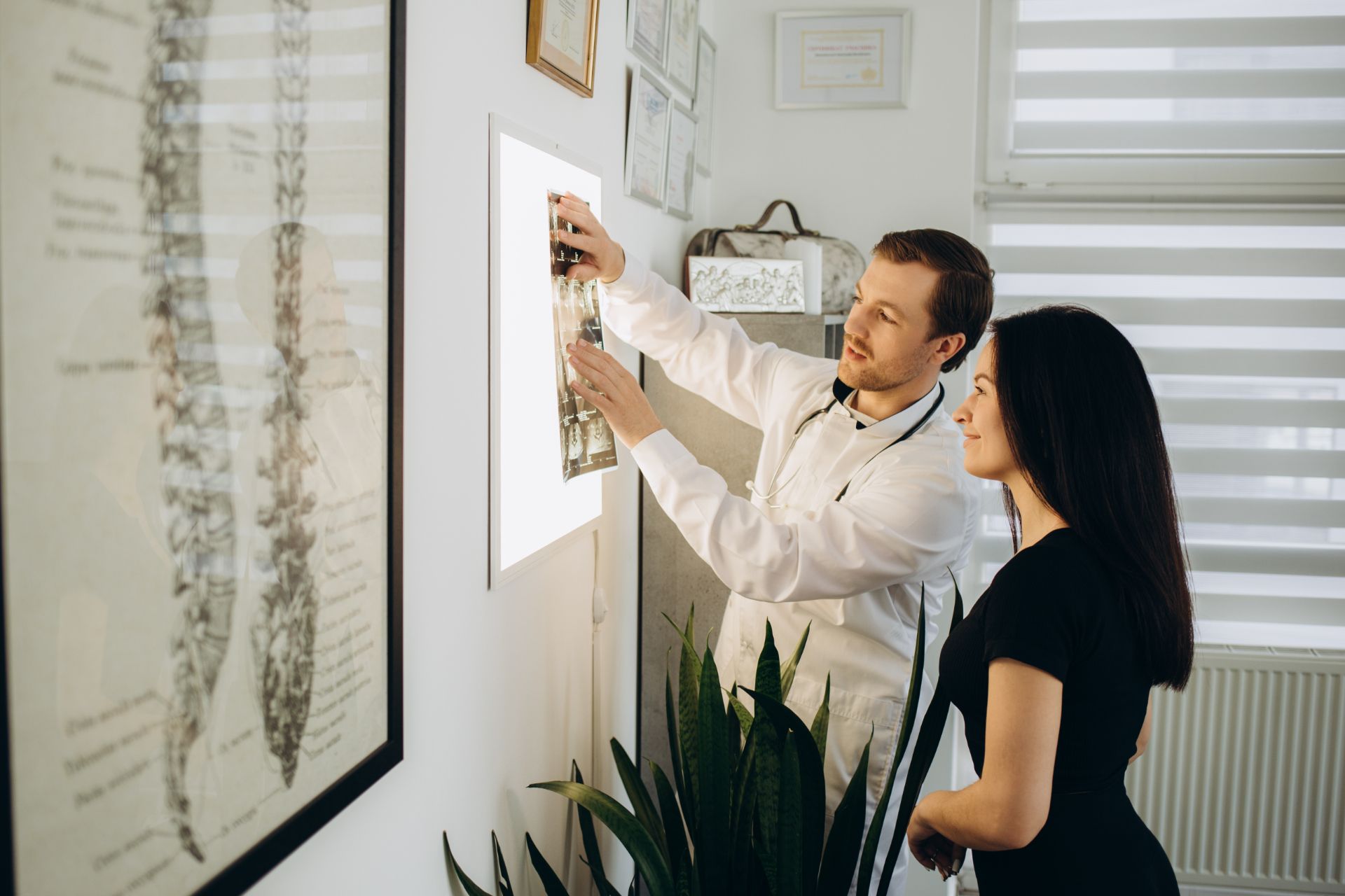 A man and a woman are looking at an x-ray of a spine. WellLife Chiropractic