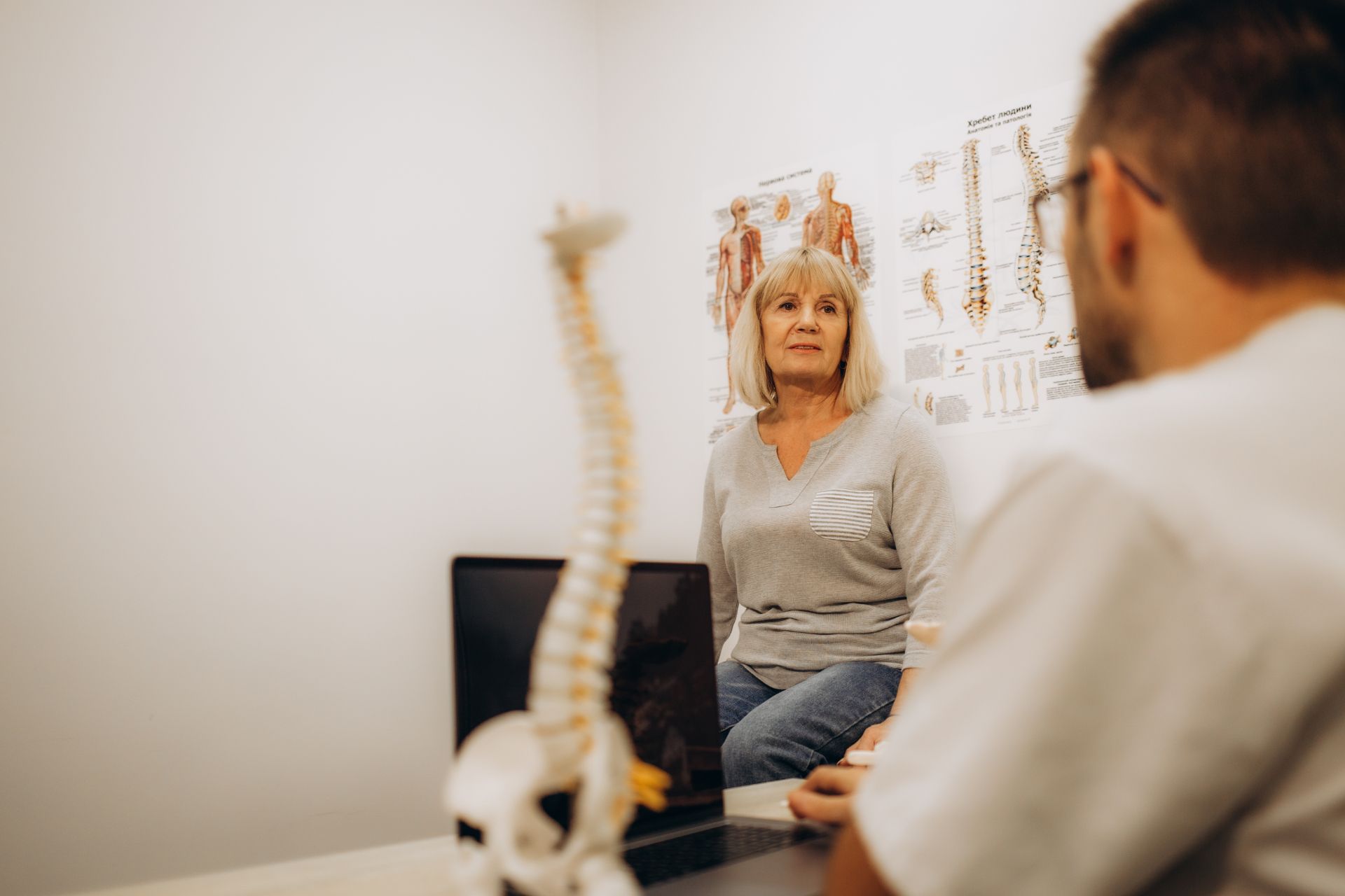 A woman is sitting at a table talking to a doctor. WellLife Chiropractic