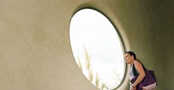 Big white chair in front of a concrete wall