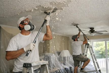 Worker scraping textured popcorn finish off a ceiling during a professional drywall service in Moreno Valley, CA.
