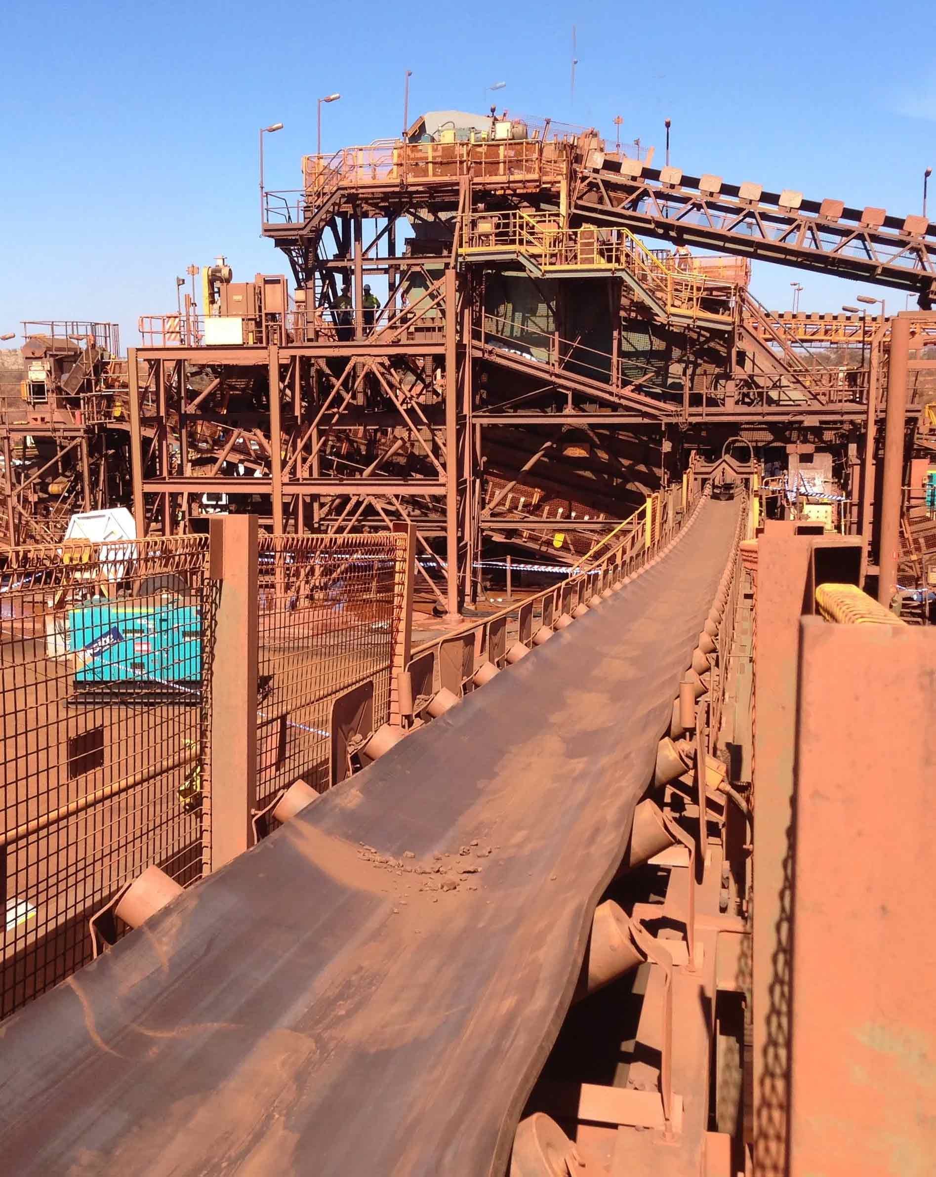 a conveyor belt is going through a large industrial area - belt is sagged