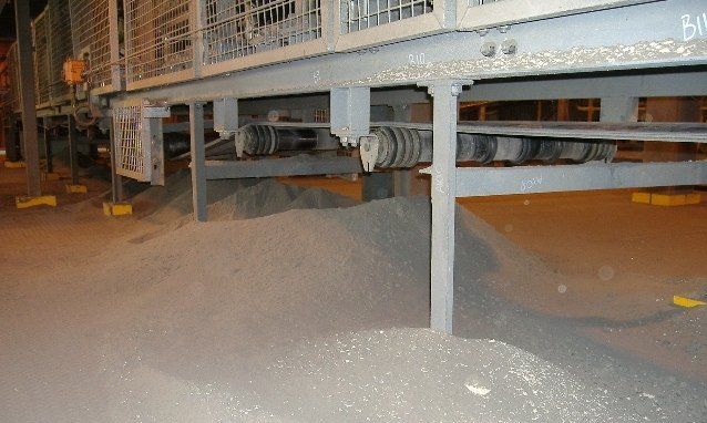 a pile of gravel is sitting under a train car 