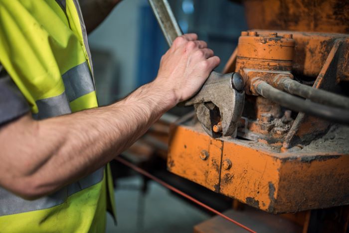 a man in a yellow vest is working on a conveyor