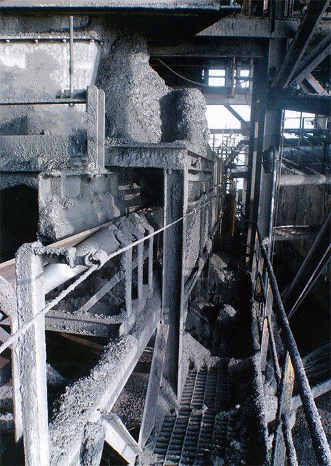 a black and white photo of a factory with a conveyor belt