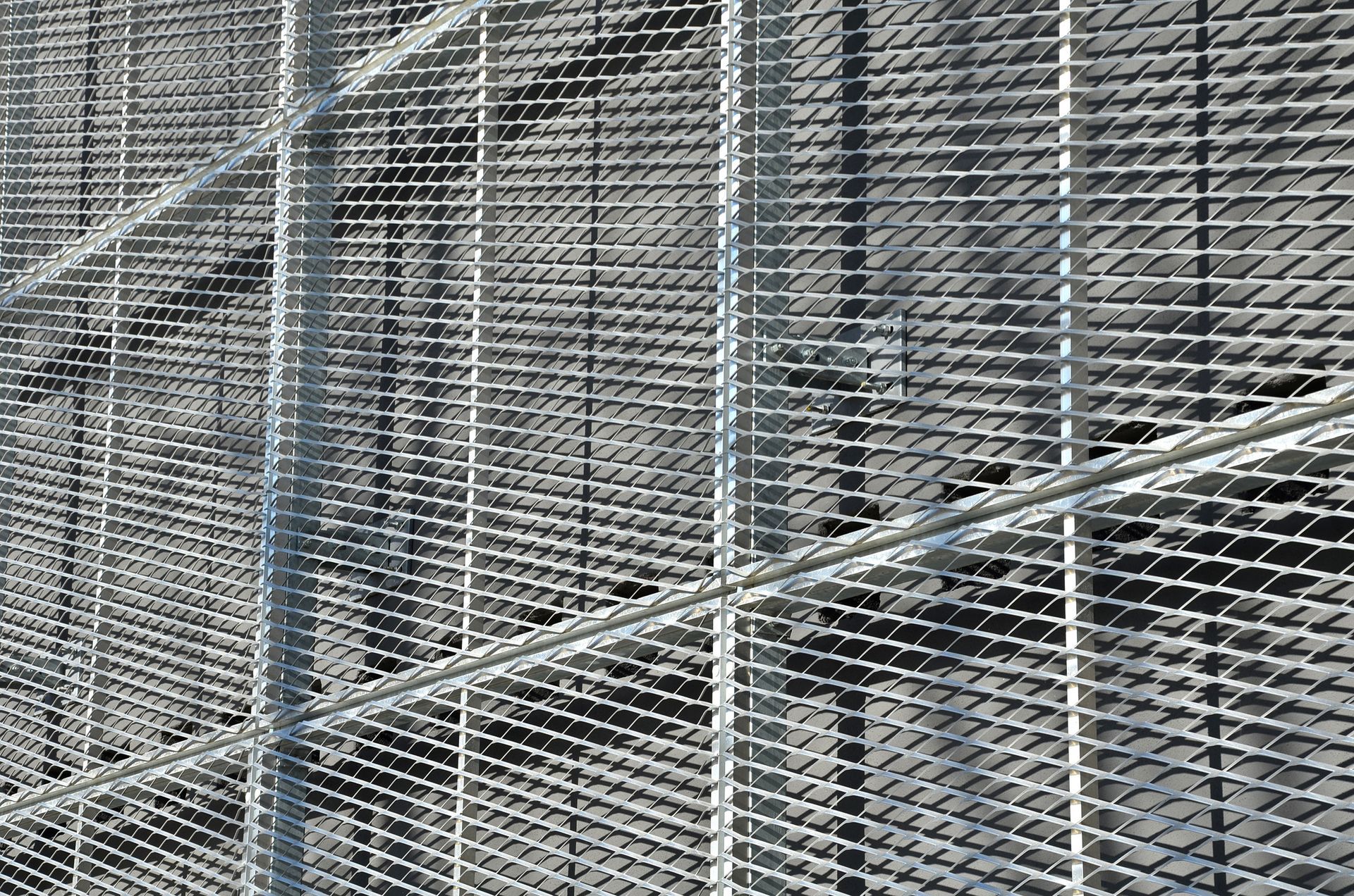 Metal grating angled against a dark background, forming a walkway or structure.