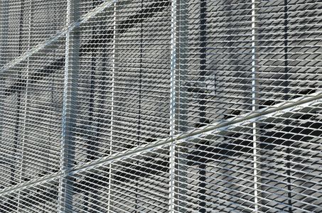Metal grating angled against a dark background, forming a walkway or structure.