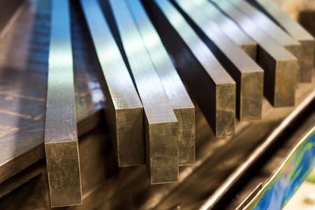 Close-up of several rectangular metal bars, stacked, reflecting light.