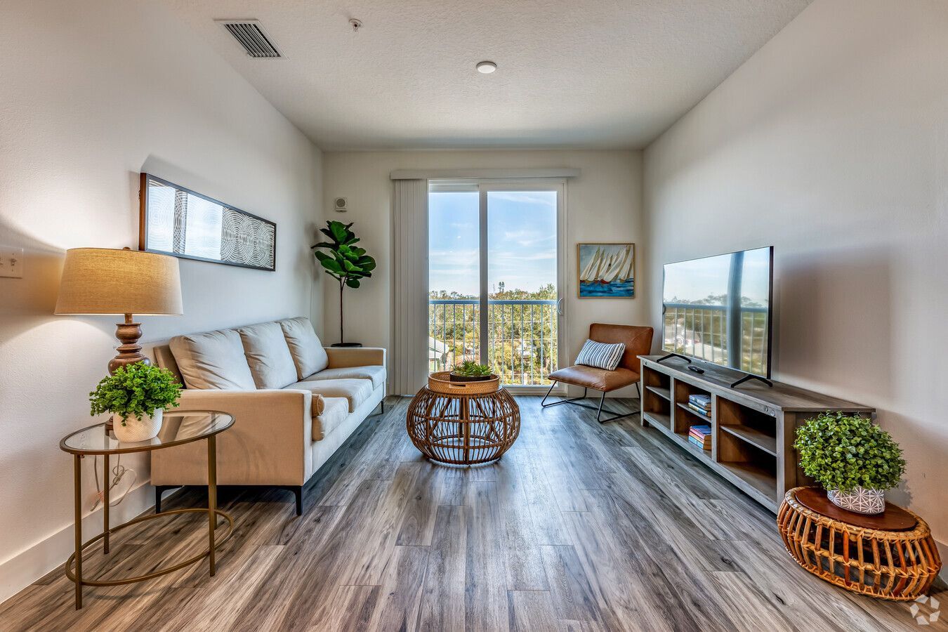 A living room with a couch , chair , table and television.