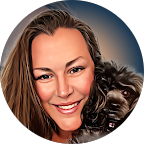 Smiling woman with blonde hair posing with a small black dog against a blue background