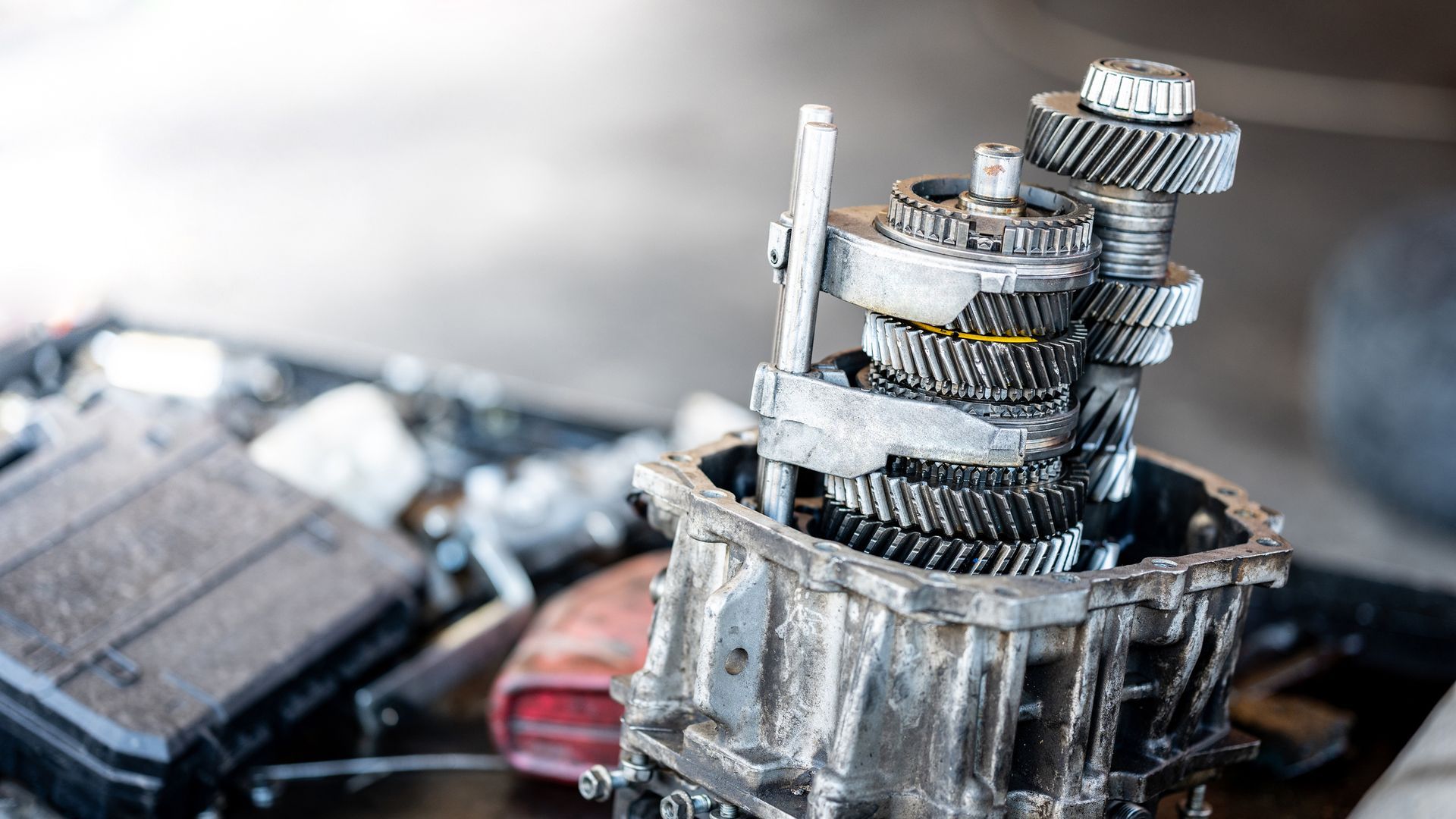 Disassembled car automatic transmission gear part or gearbox on workbench in auto repair shop.