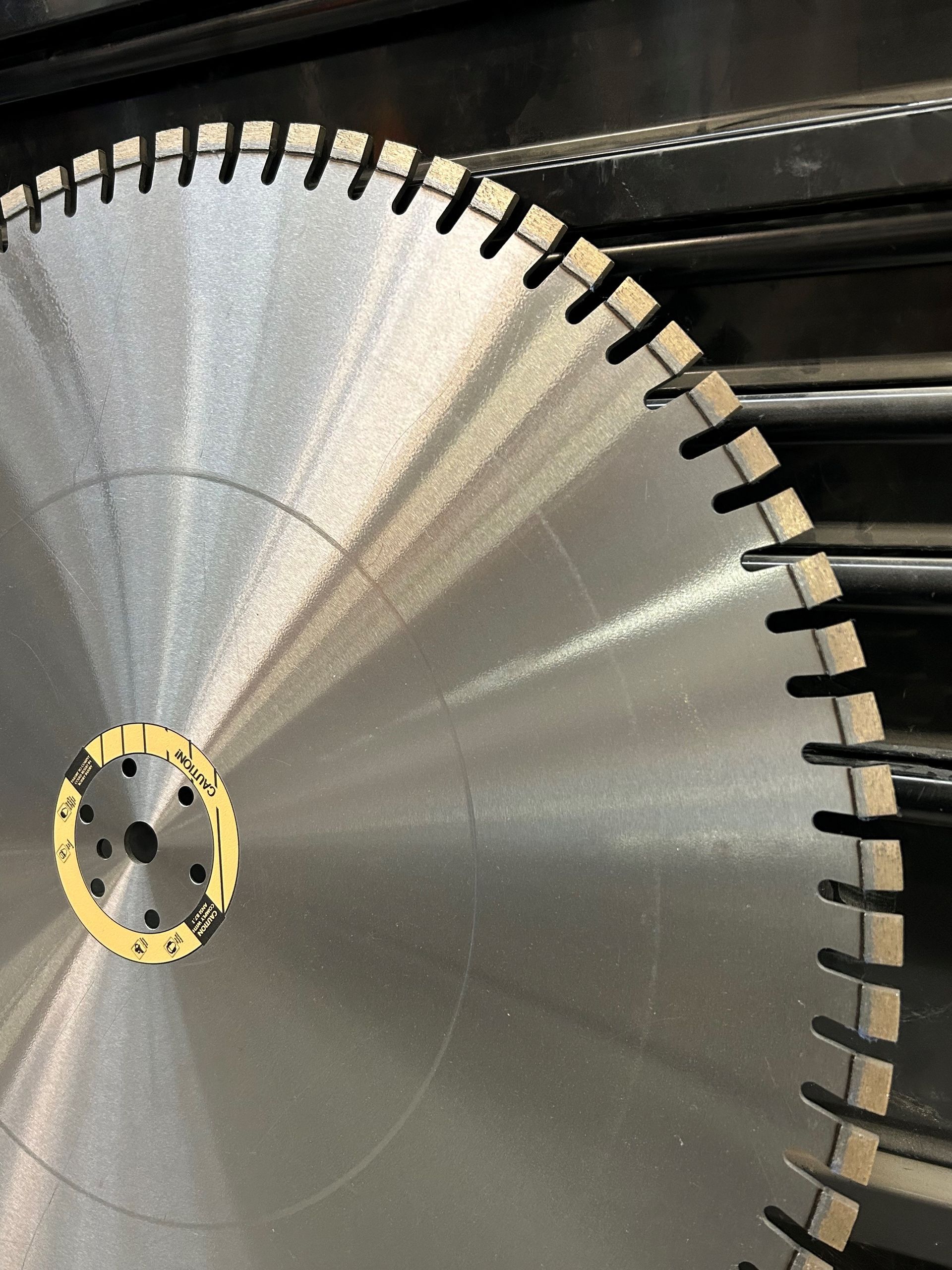 Large, circular metal saw blade with notched teeth and a central mounting hole.