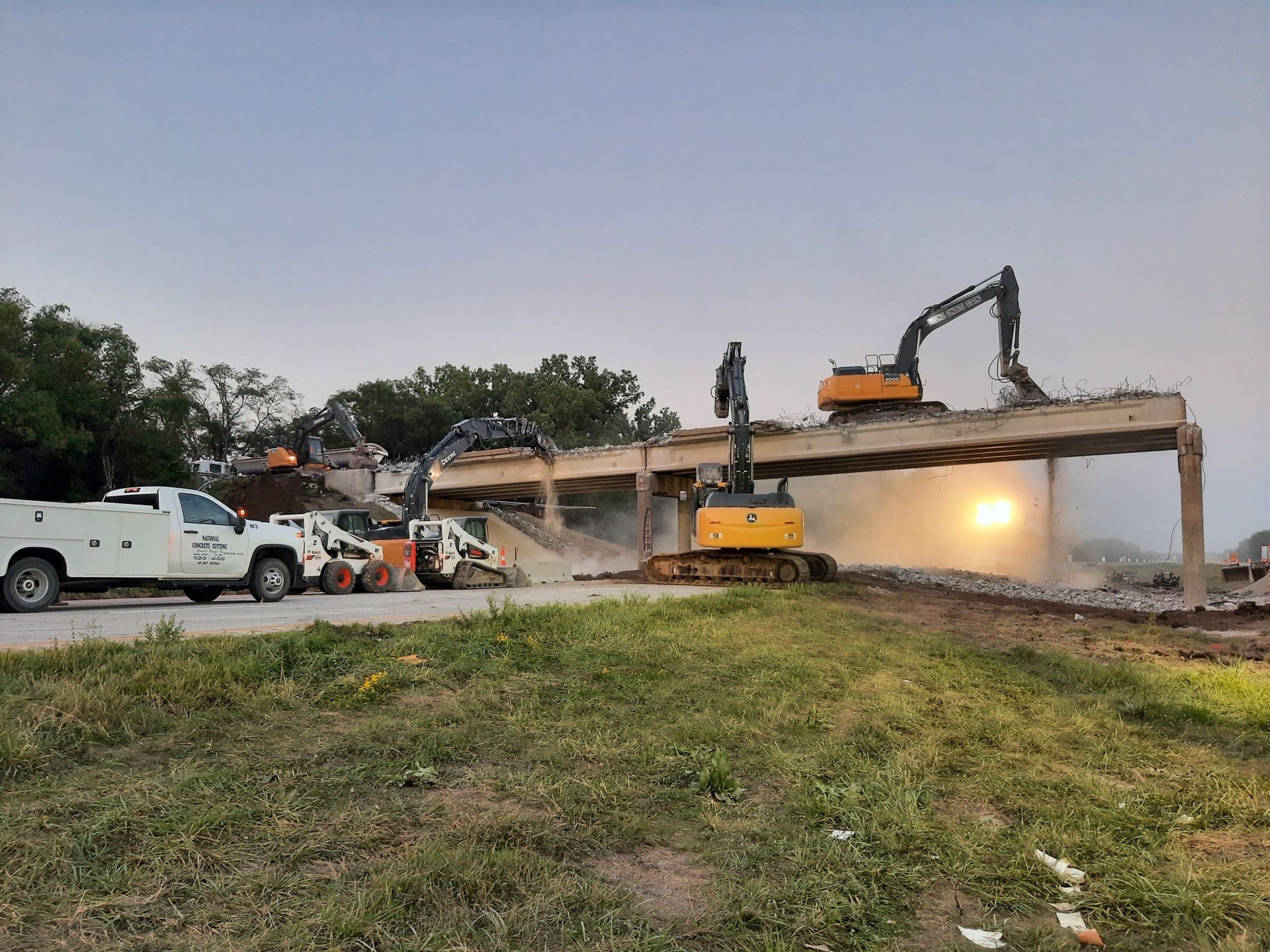 An excavator tearing down a brick construction during an urban demolition Construction equipment dismantles a bridge, with cranes and excavators engaged in the demolition.