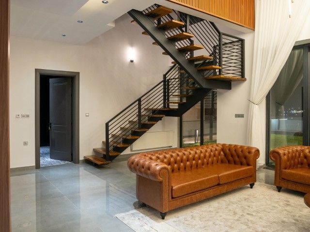Modern Suffolk home's interior with a brown leather sofa and a floating wooden staircase. Modern interior with a brown leather sofa and a floating wooden staircase.