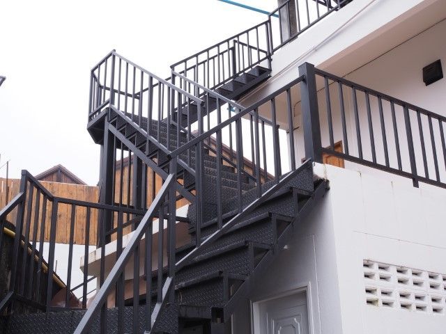 Black metal exterior staircase on a white Portsmouth building, leading up to a balcony.