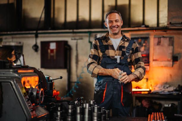 A man working near machinery and metal rods.