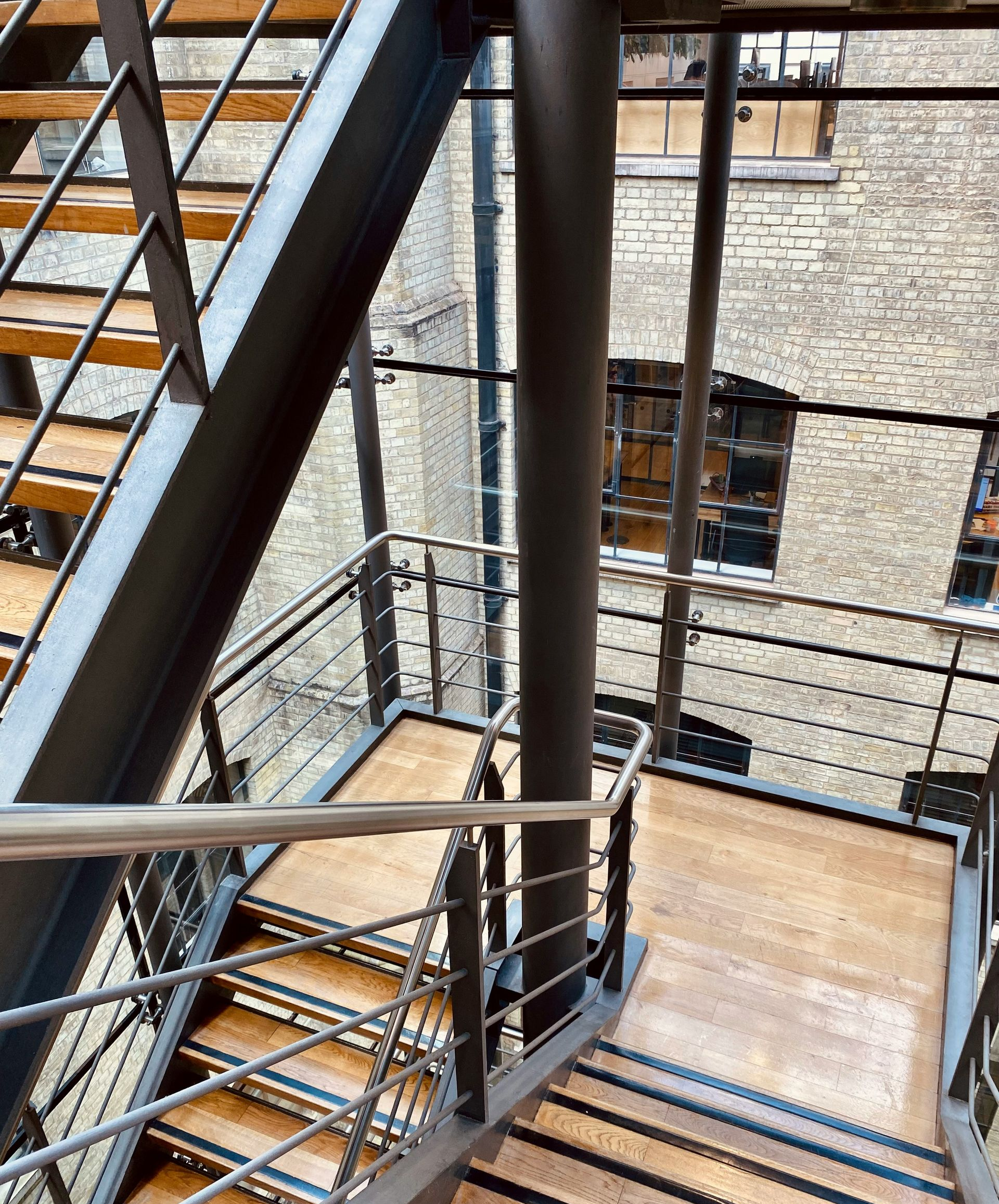 A staircase with metal railings and wooden steps viewed from above