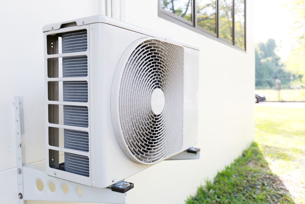 A White Air Conditioner is Mounted on the Side of a Building — Davies Refrigeration & Air Conditioning in Beerwah, QLD