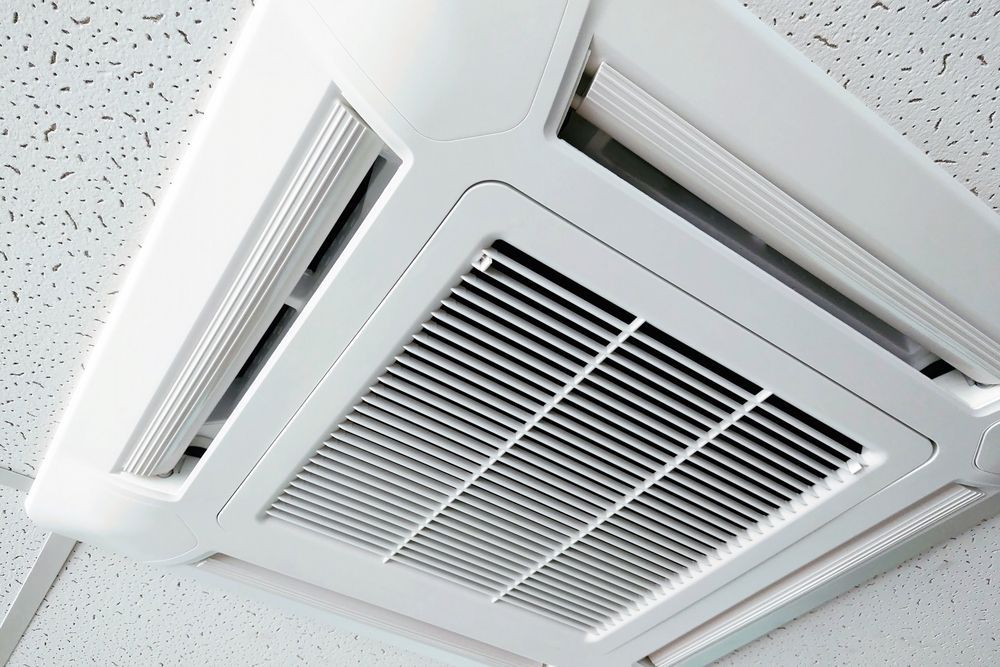 A White Air Conditioner is Mounted to the Ceiling of a Room — Davies Refrigeration & Air Conditioning in Warana, QLD