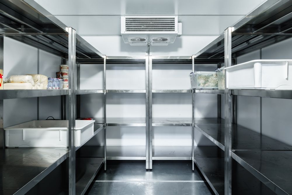 An Empty Refrigerator With Stainless Steel Shelves in a Kitchen — Davies Refrigeration & Air Conditioning in Warana, QLD