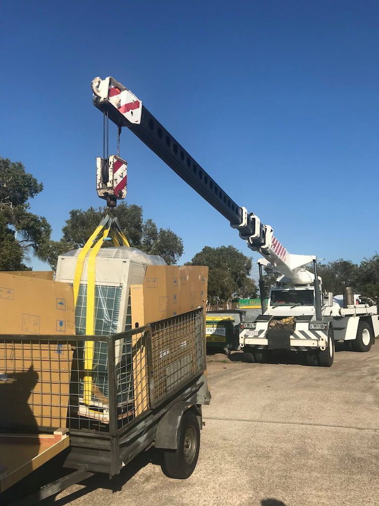 A Crane is Lifting a Large Piece of Equipment on a Trailer — Davies Refrigeration & Air Conditioning in Kawana, QLD
