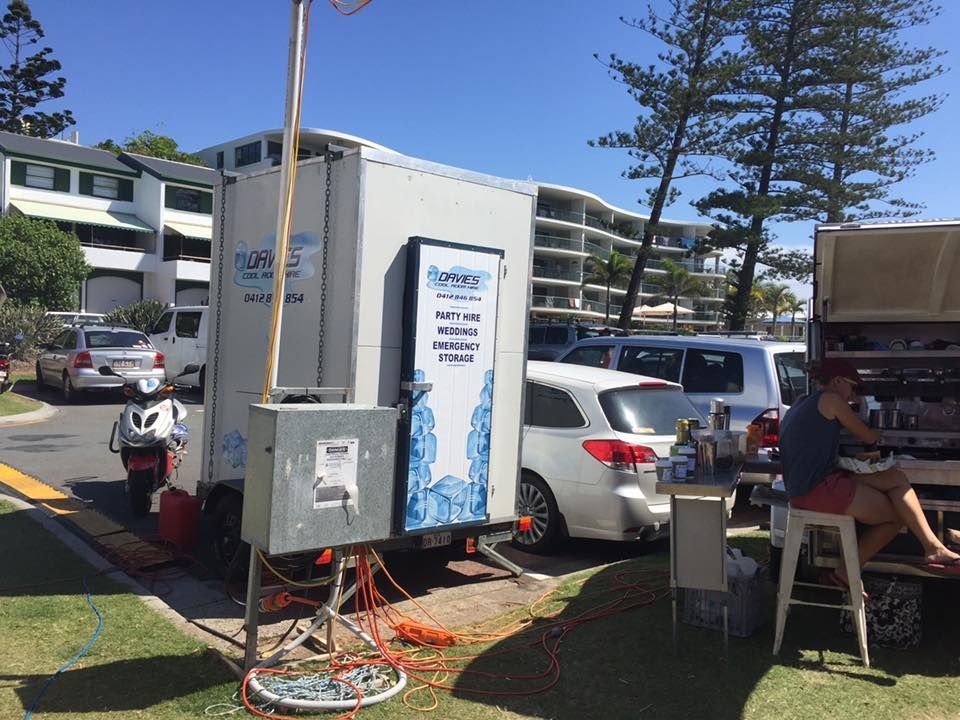 A Man is Sitting at a Table in Front of a Trailer — Davies Refrigeration & Air Conditioning in Warana, QLD