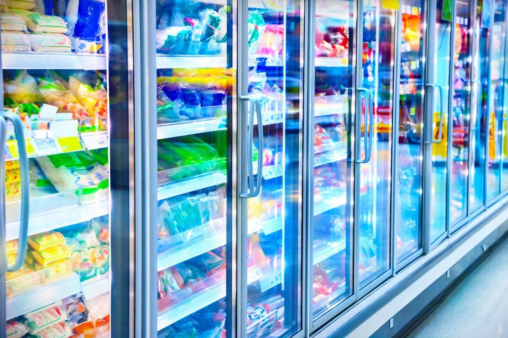A Row of Refrigerators in a Grocery Store Filled With Lots of Food — Davies Refrigeration & Air Conditioning in Warana, QLD