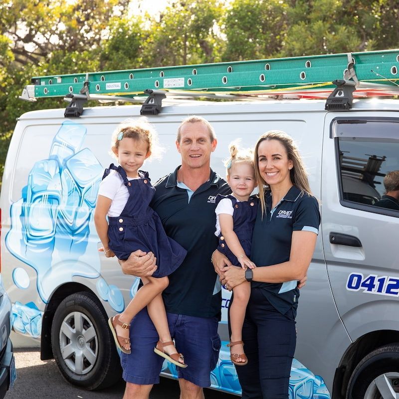A Family Standing in Front of a Van — Davies Refrigeration & Air Conditioning in Warana, QLD