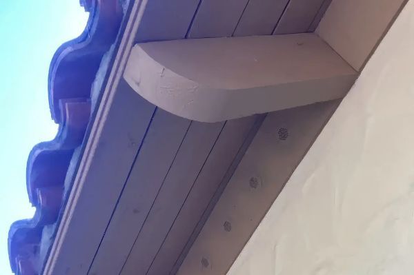 A close up of a wooden roof with a blue sky in the background.