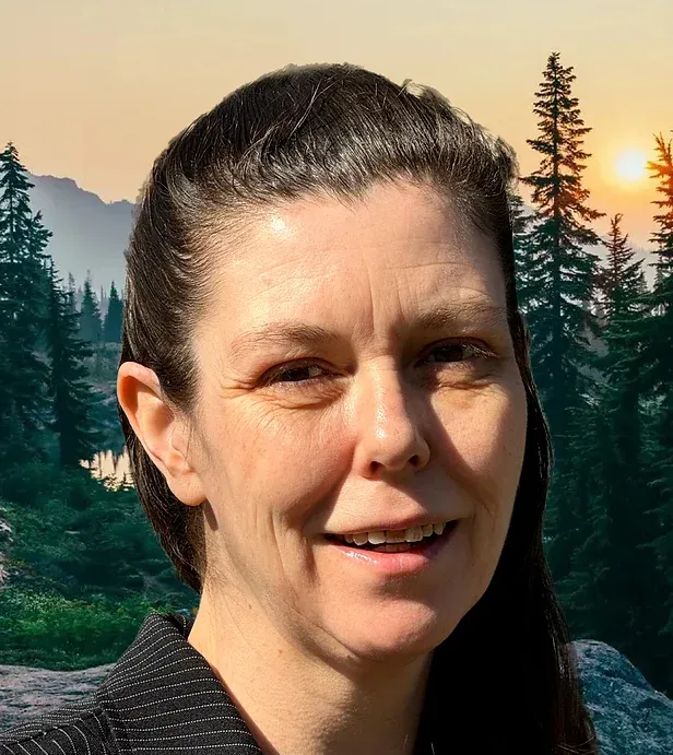 Woman with dark hair smiling; forest and sunset backdrop.