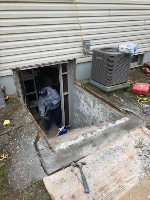 A man is looking out of a basement window.