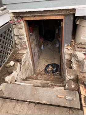 A basement door is being built into a stone wall.